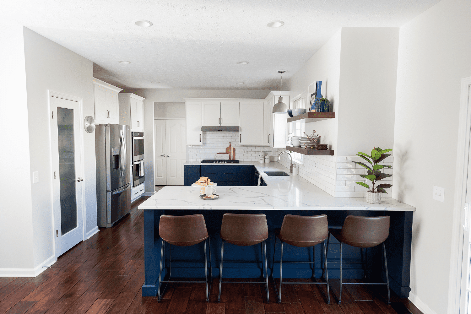 Nicholas Design Build | A kitchen with a blue island and bar stools.