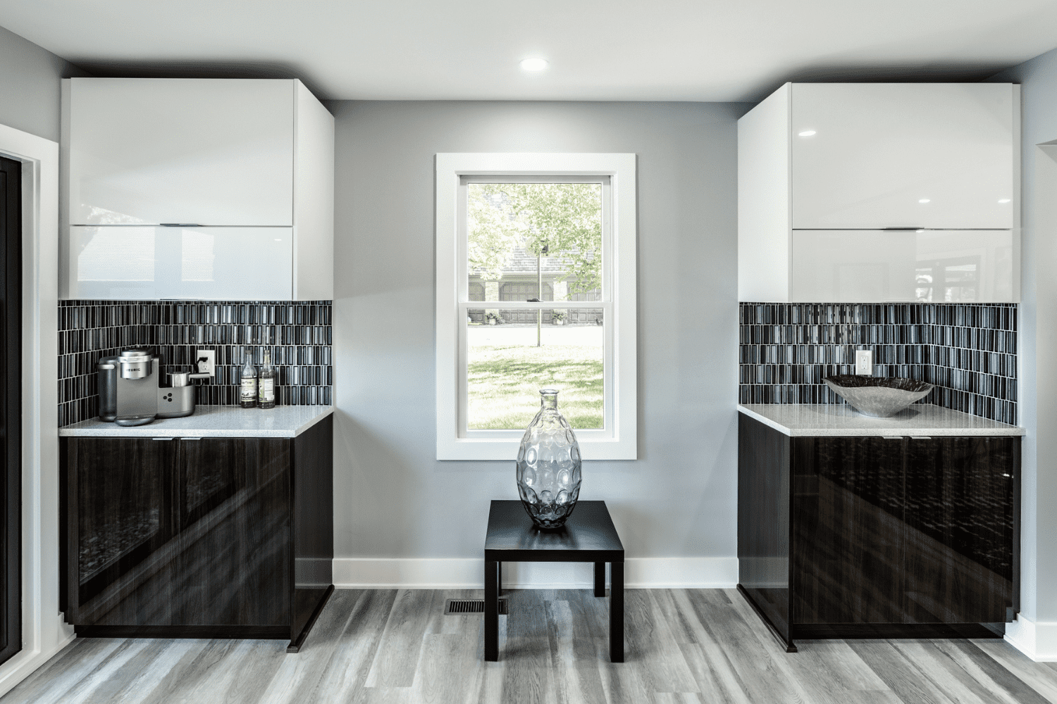 Nicholas Design Build | A bathroom with black and white cabinets and a window.