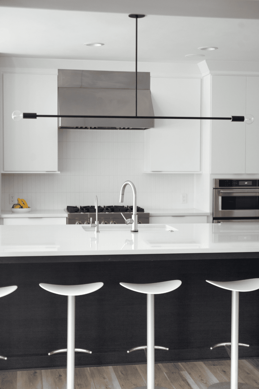 Nicholas Design Build | A black and white kitchen with stools.