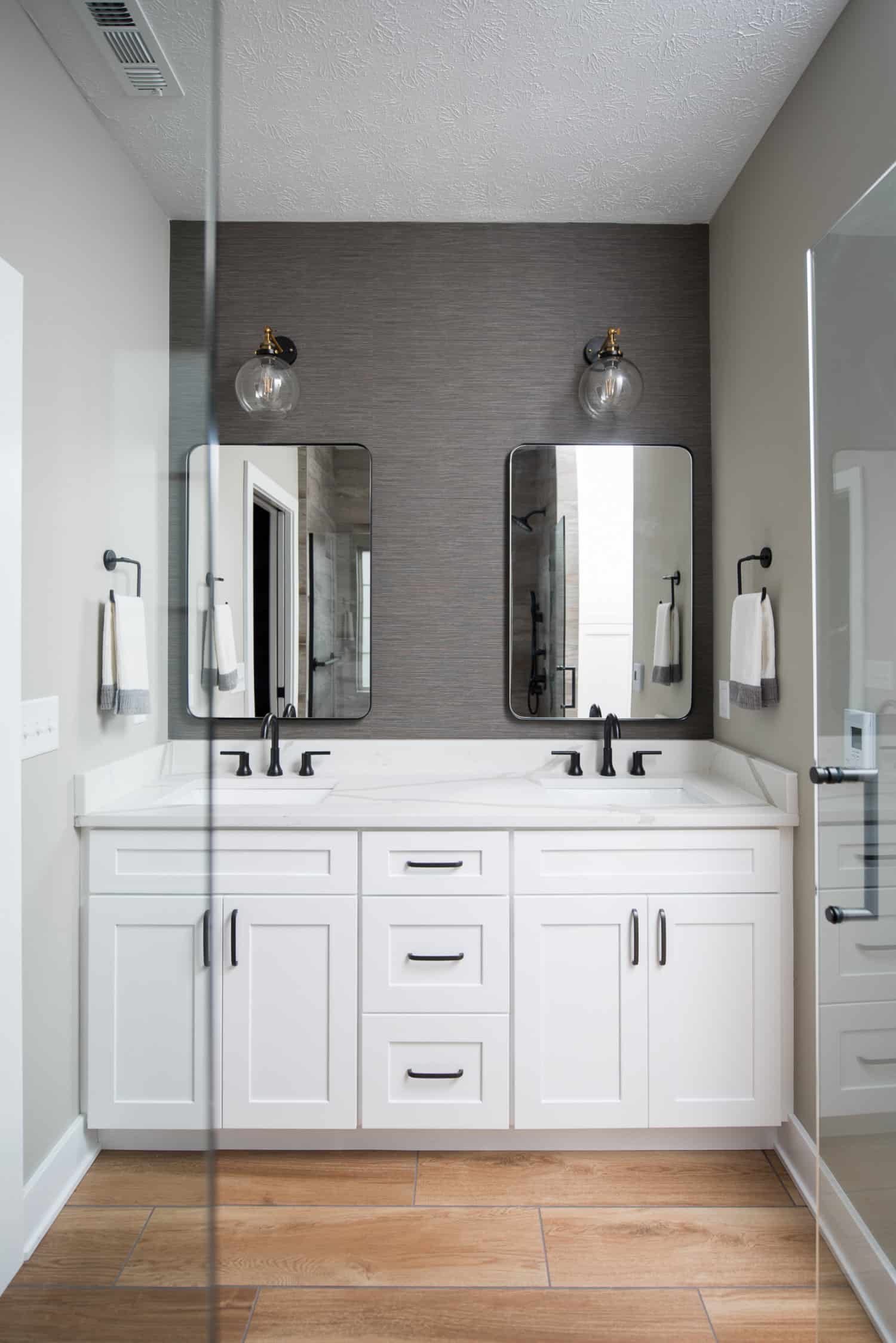 Nicholas Design Build | A modern white bathroom with two contemporary sinks and mirrors.
