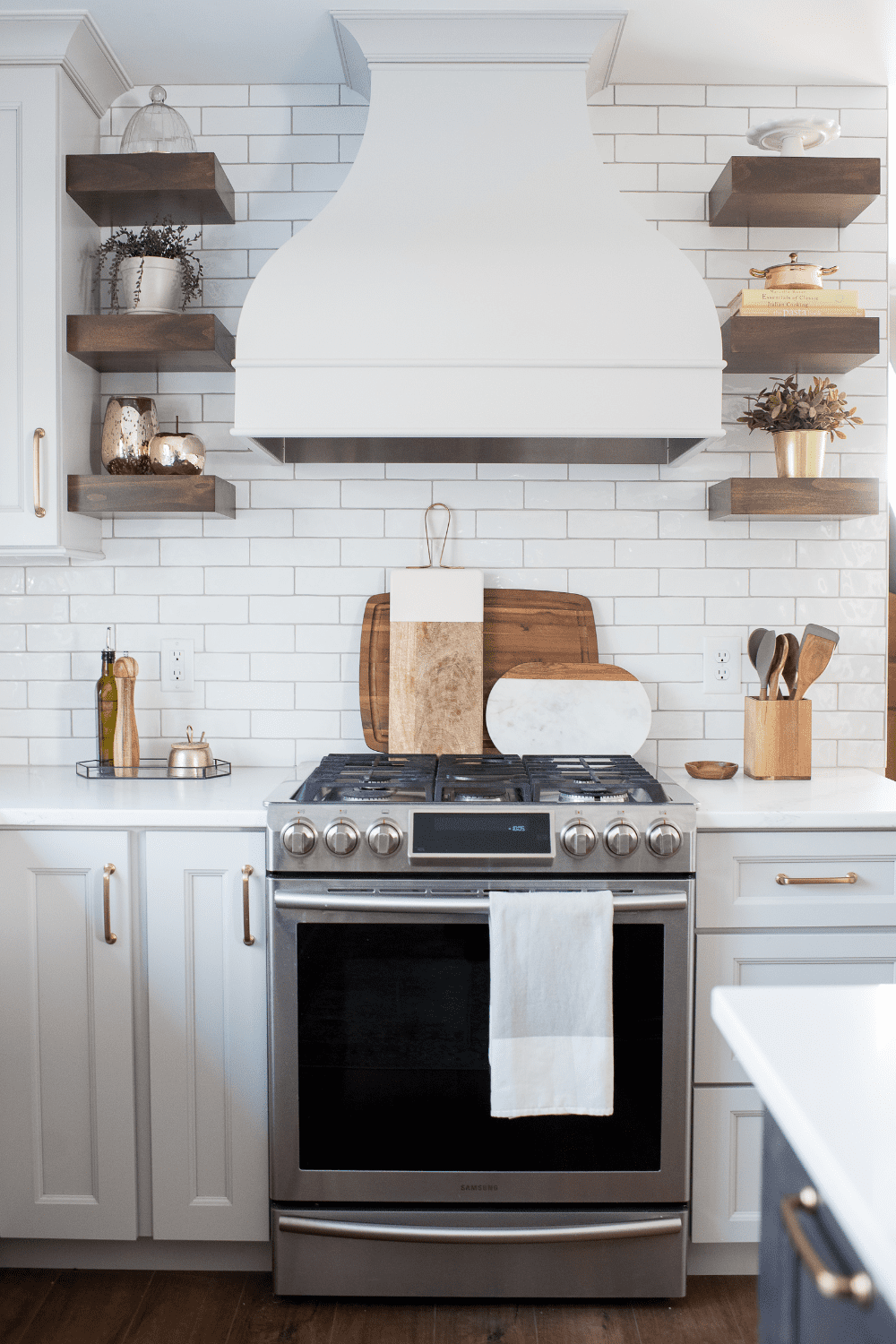 Nicholas Design Build | A neutral kitchen with wooden shelves and a stove.