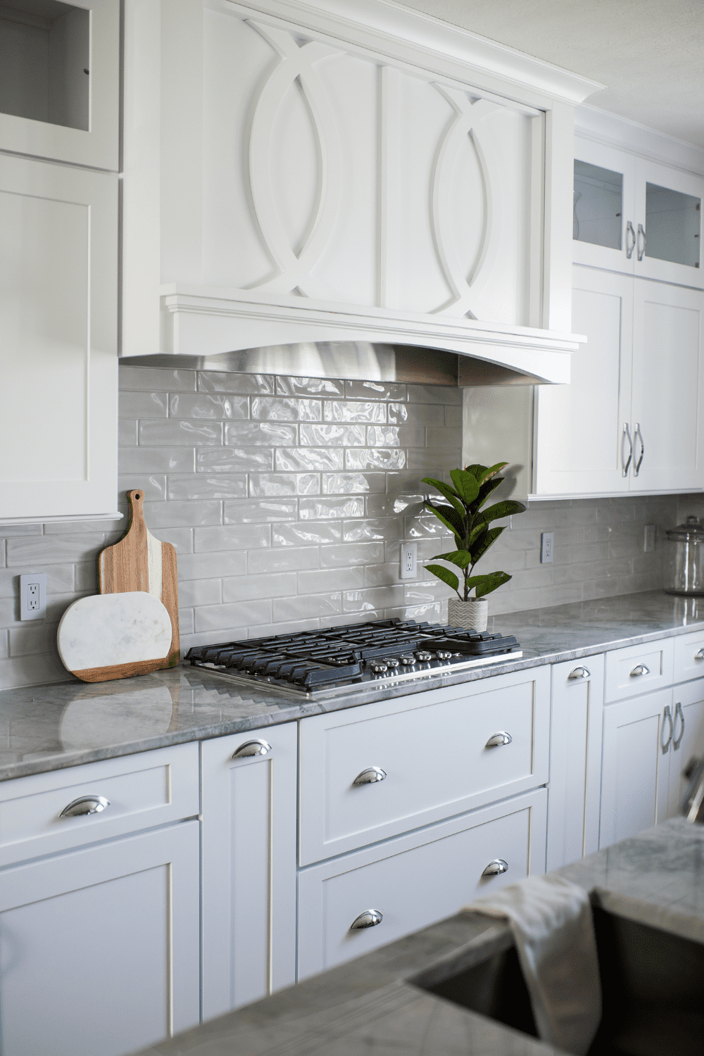 Nicholas Design Build | A kitchen with white cabinets and a white hood.