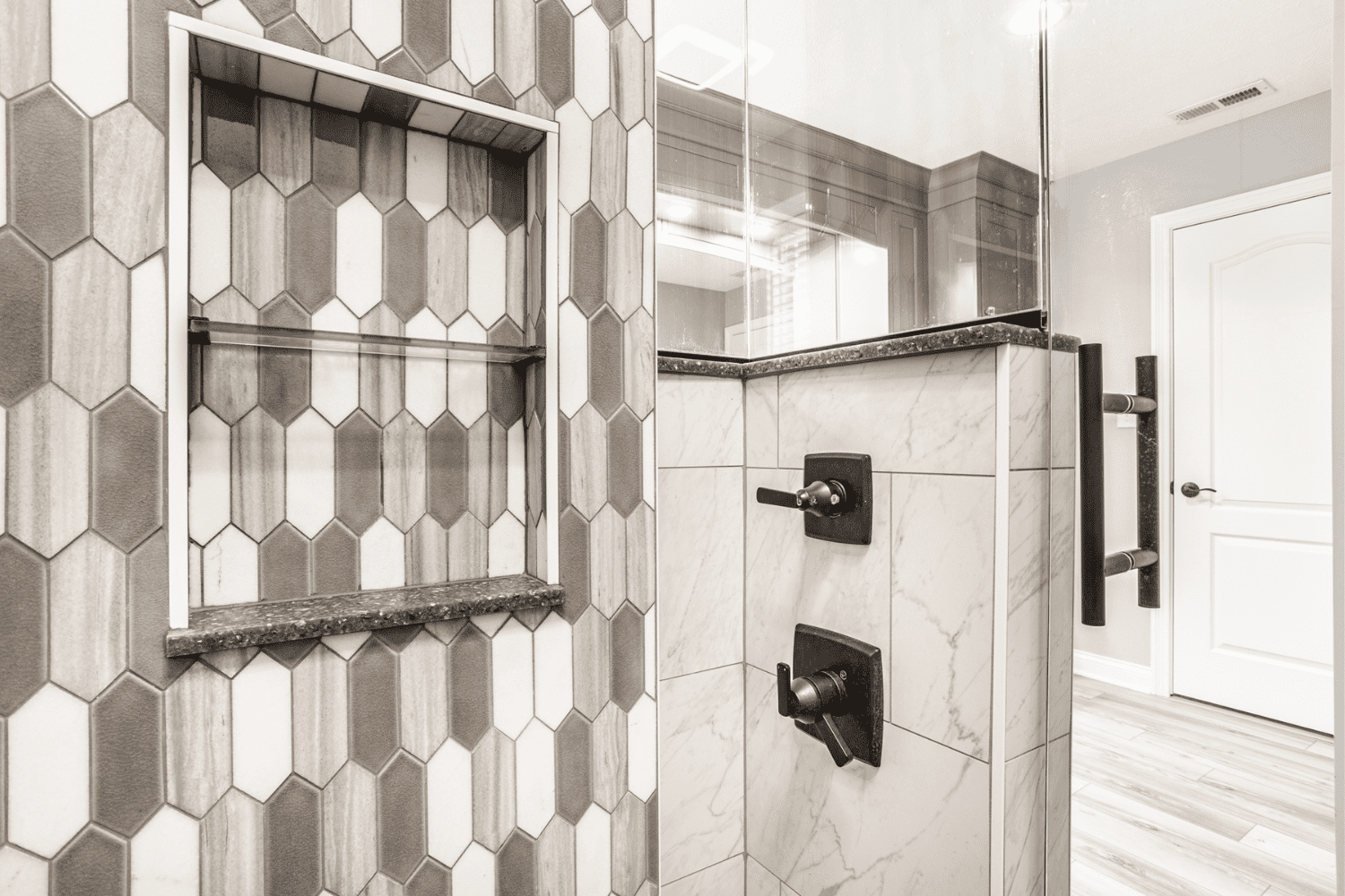 Nicholas Design Build | A black and white photo of a bathroom with tiled walls.