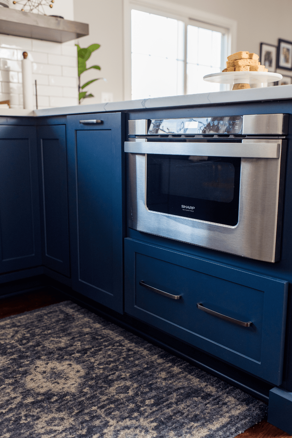 Nicholas Design Build | A kitchen with blue cabinets and a microwave.