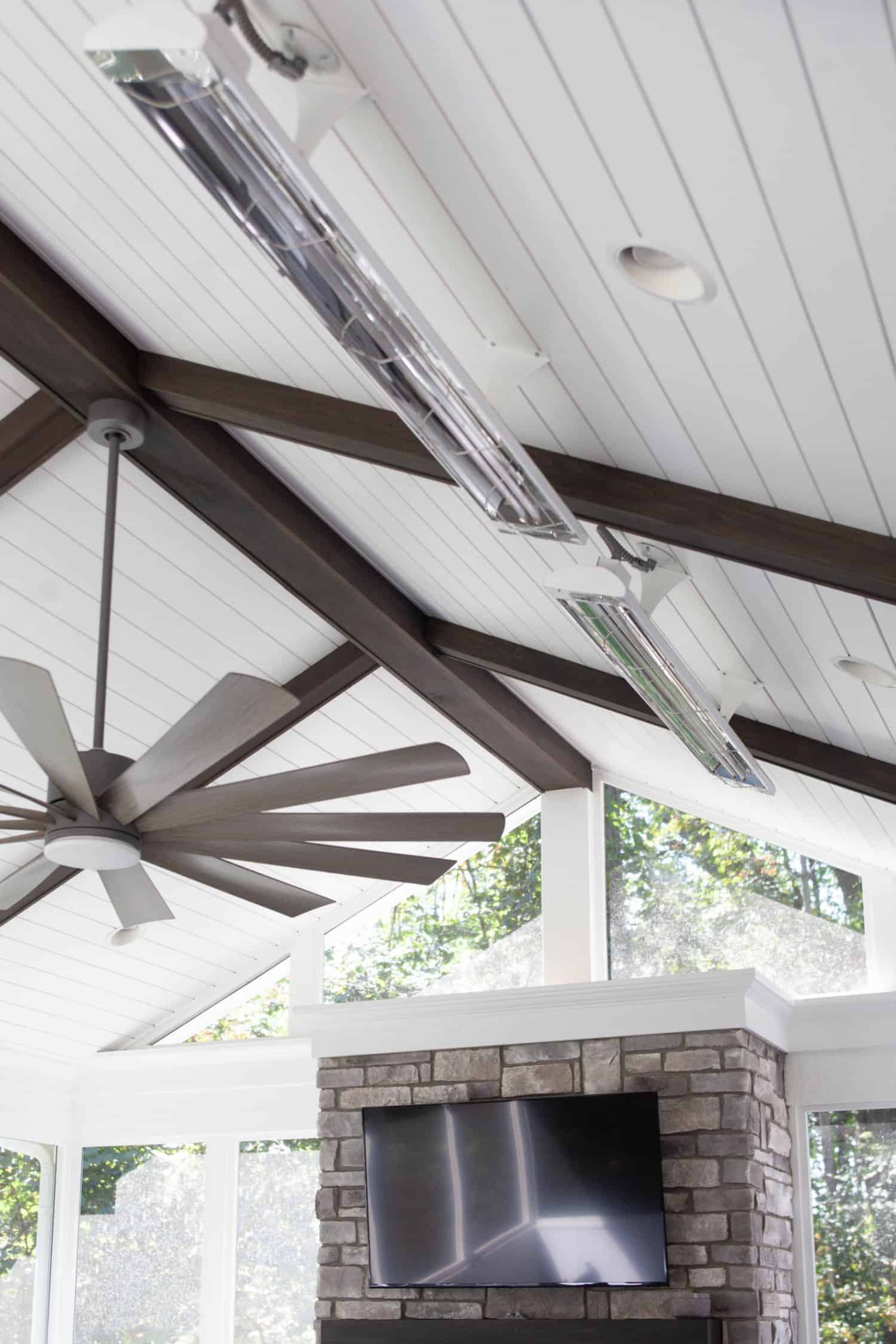 Nicholas Design Build | A living room with a fireplace and ceiling fan.
