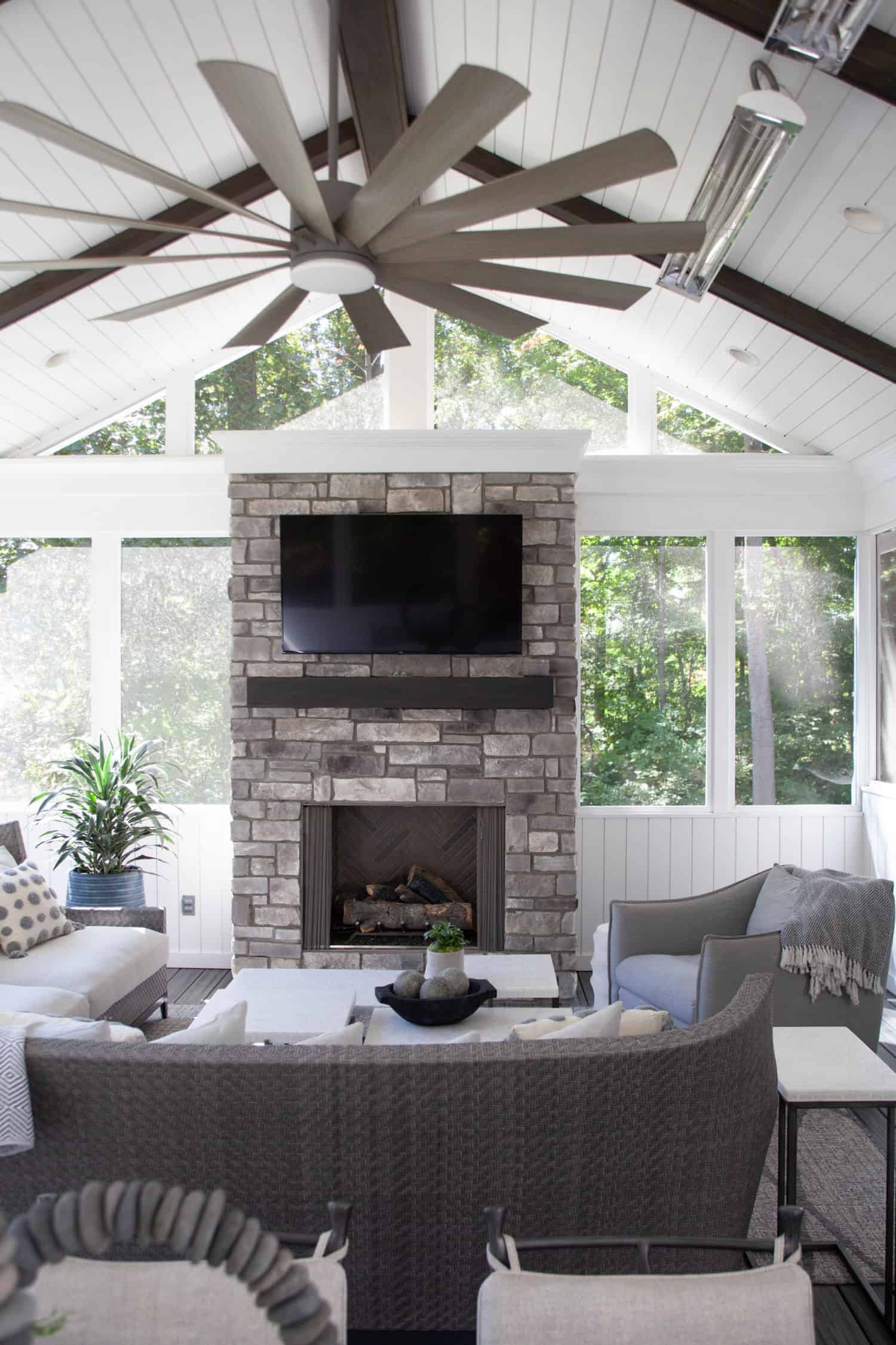 Nicholas Design Build | A living room with a fireplace and a ceiling fan.