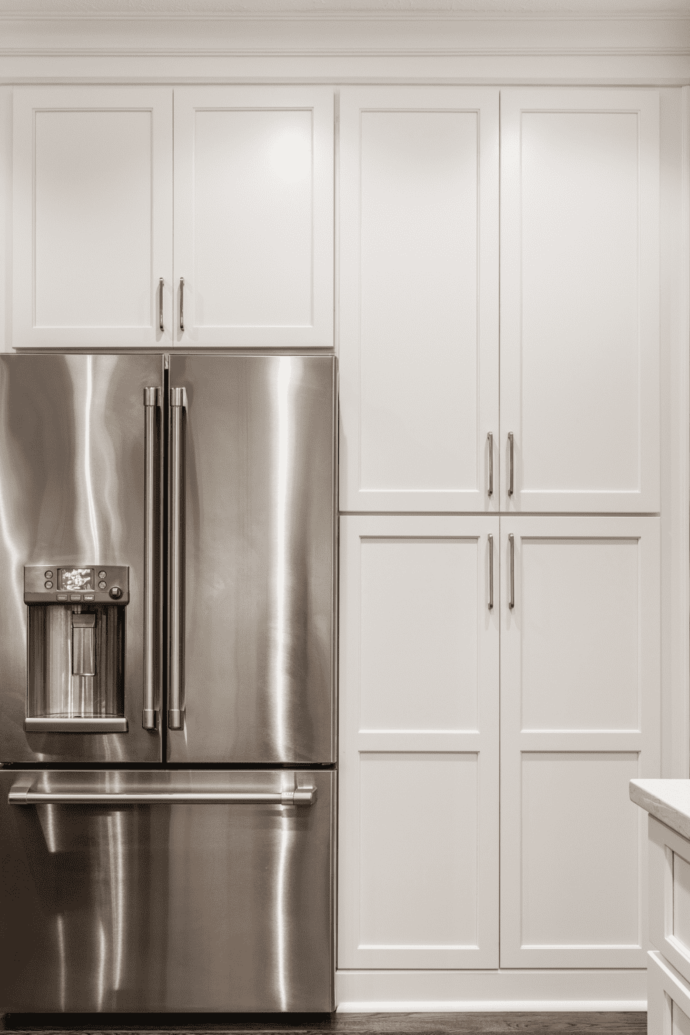 Nicholas Design Build | A stainless steel refrigerator in a white kitchen.