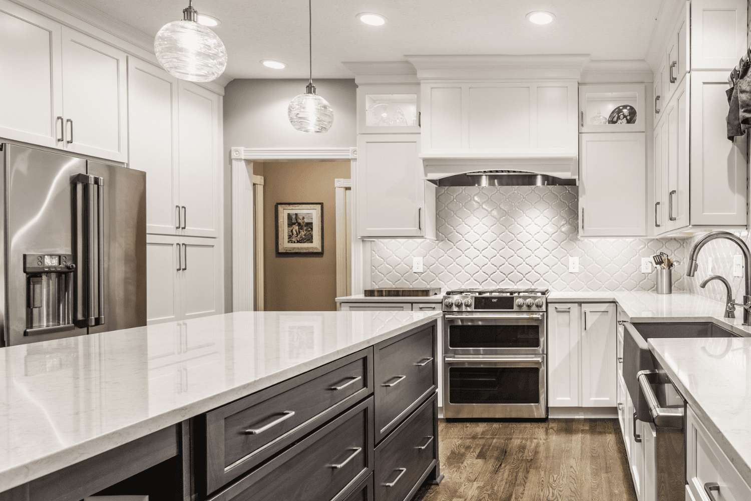 Nicholas Design Build | A white kitchen with stainless steel appliances.
