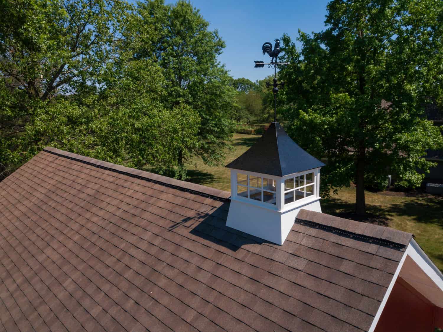 Nicholas Design Build | An aerial view of a remodel brown roof with a clock on top.