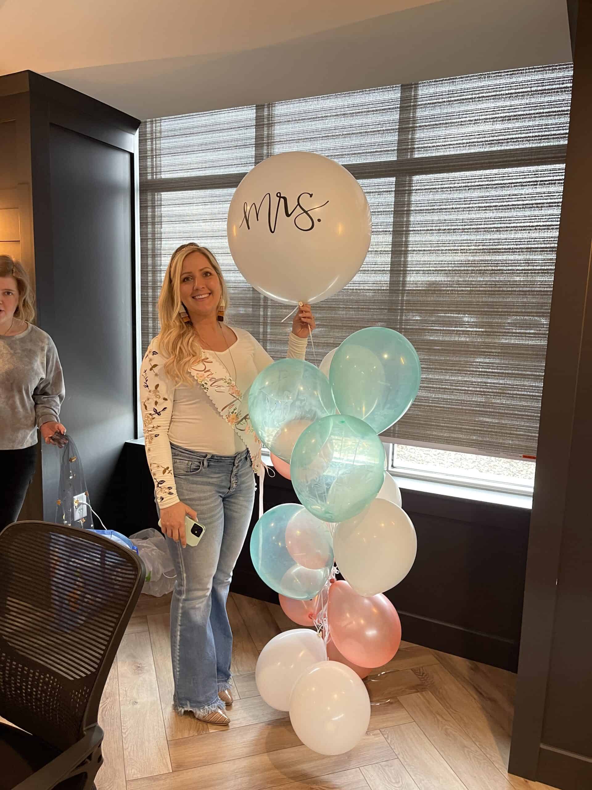 Nicholas Design Build | Two women standing next to balloons with the word mrs.