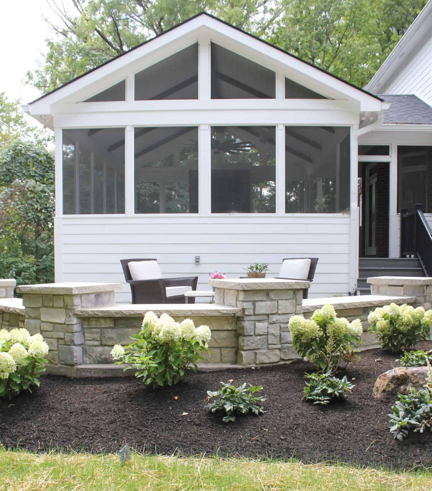 Nicholas Design Build | A screened in porch with landscaping around it.