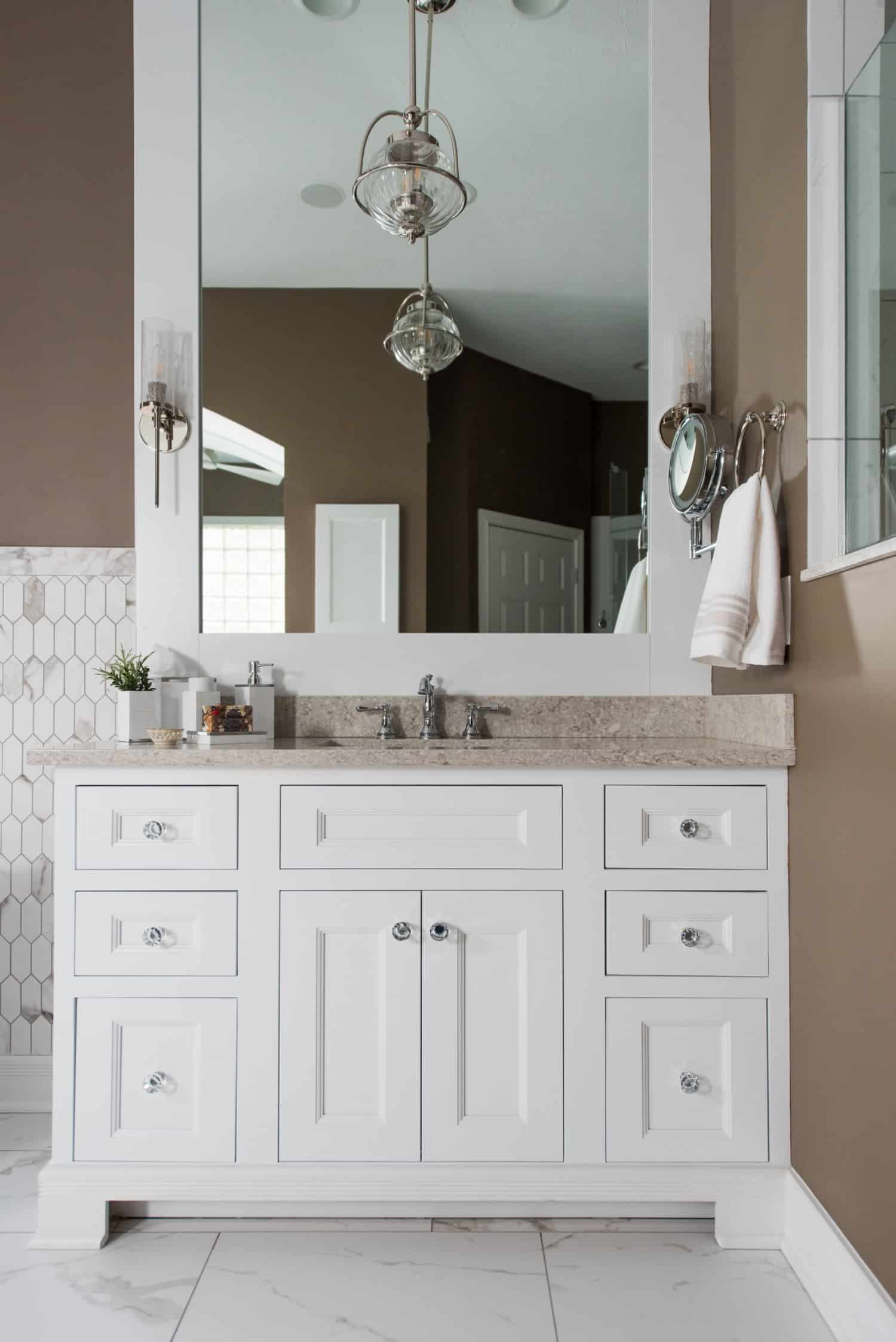 Nicholas Design Build | An oasis of tranquility, featuring a bathroom with white cabinets and a mirror.