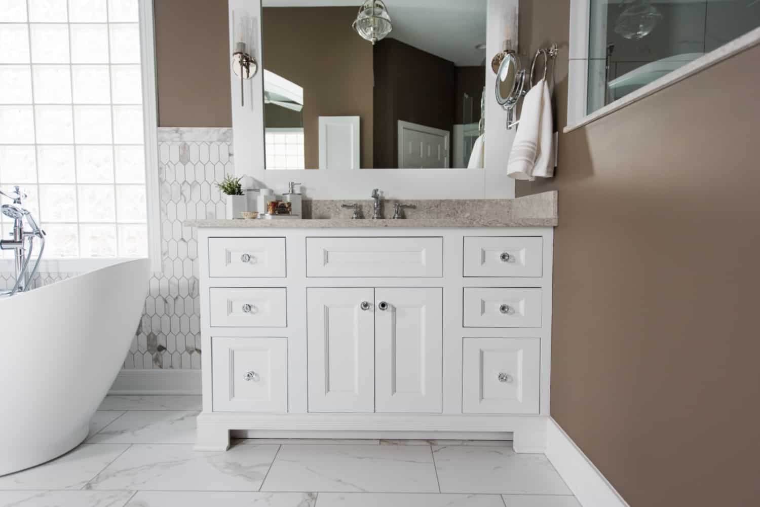 Nicholas Design Build | A bathroom oasis with a white vanity and a tub.