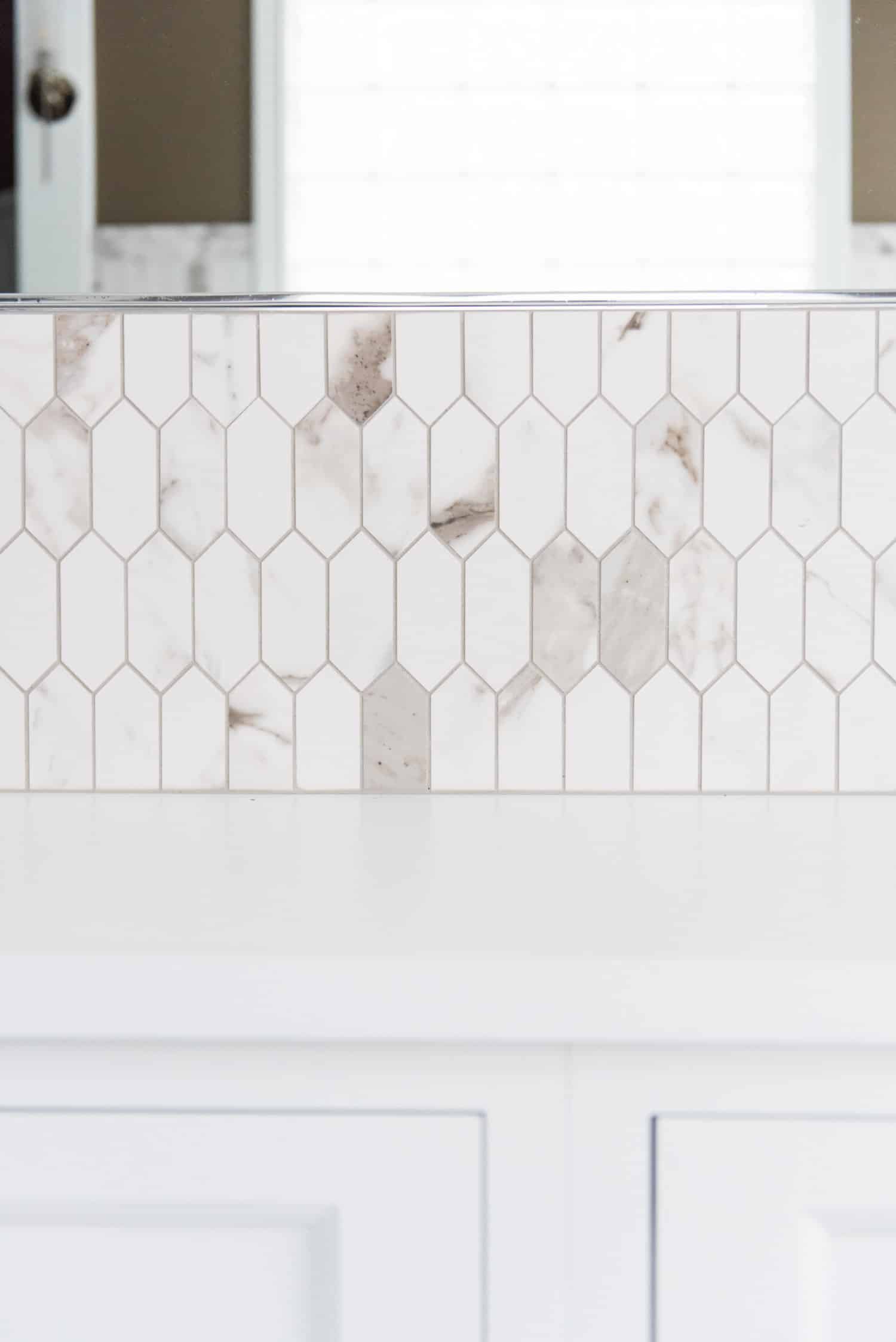 Nicholas Design Build | A white bathroom with a hexagonal tile backsplash resembling an oasis.