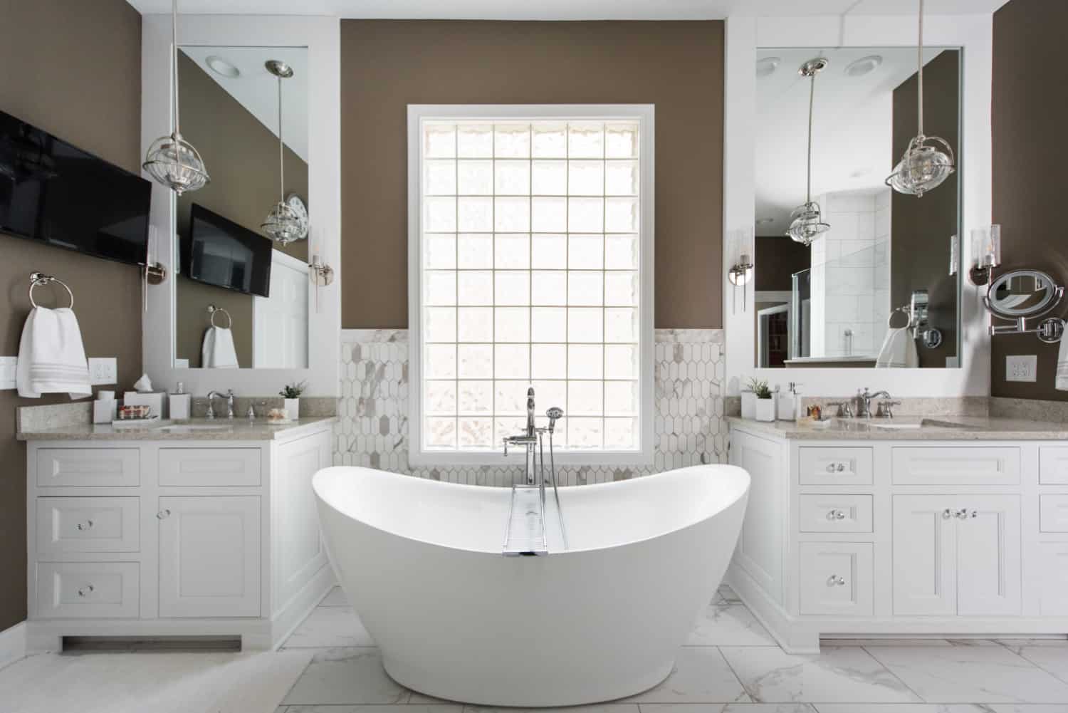 Nicholas Design Build | An oasis-like bathroom with a white tub and brown walls.