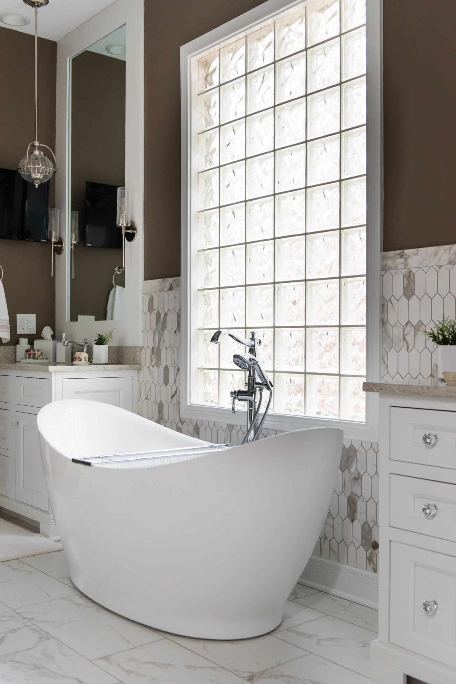 Nicholas Design Build | An oasis of relaxation found in a bathroom with brown walls, complete with a white bathtub.