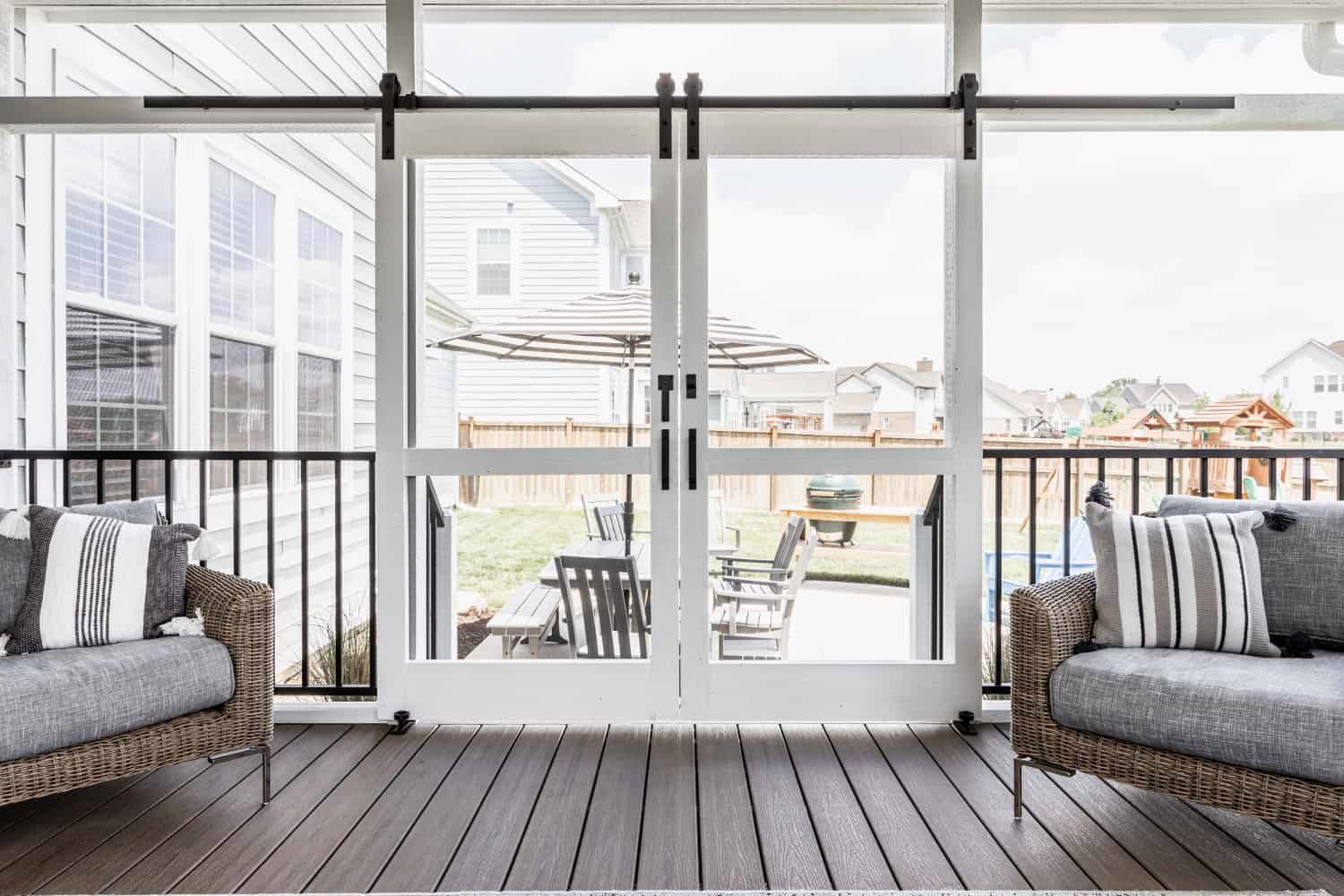 Nicholas Design Build | A remodeled patio with wicker furniture and a sliding glass door.