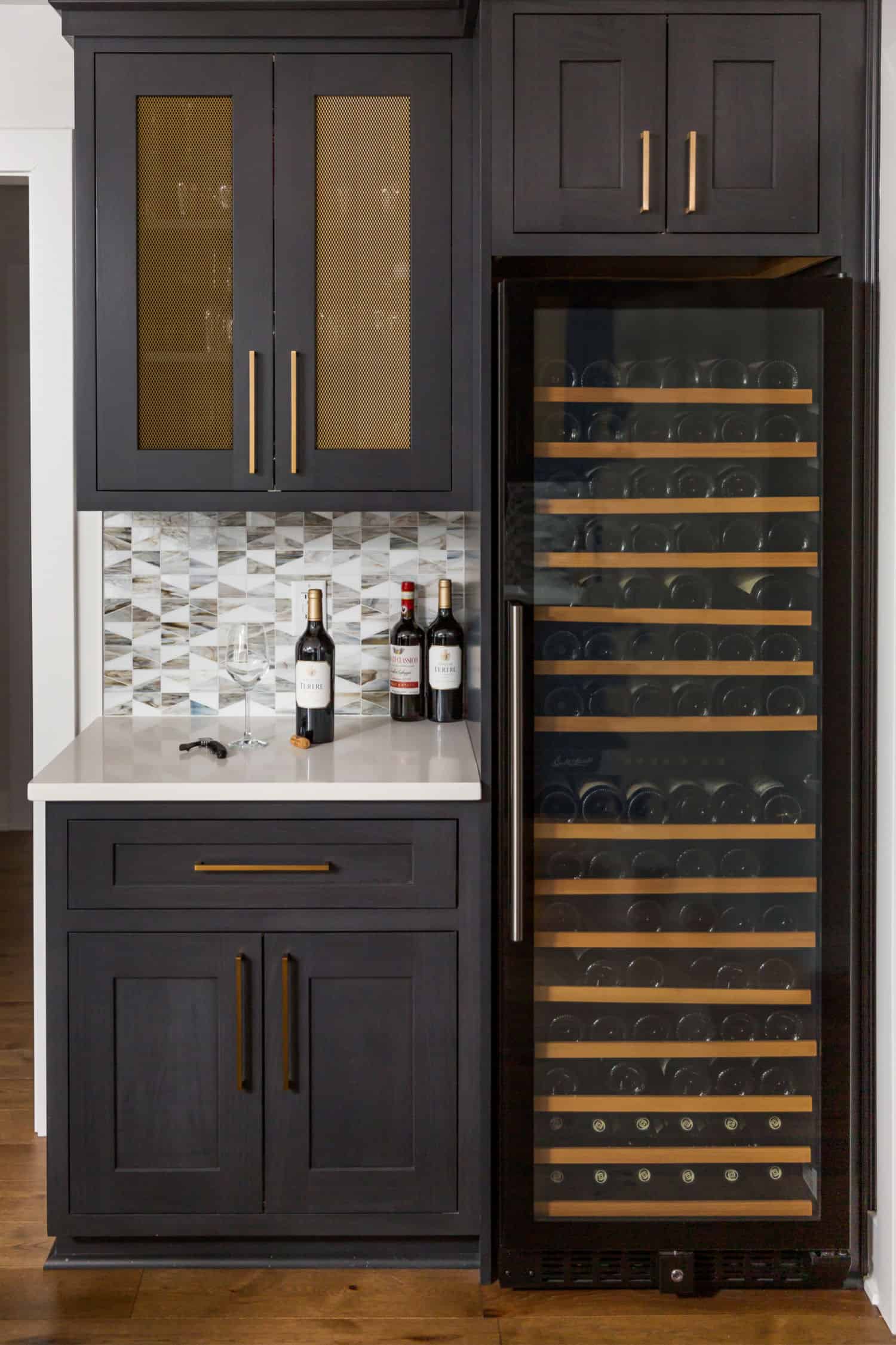 Nicholas Design Build | A remodelled kitchen with a sleek wine cooler and black cabinets.