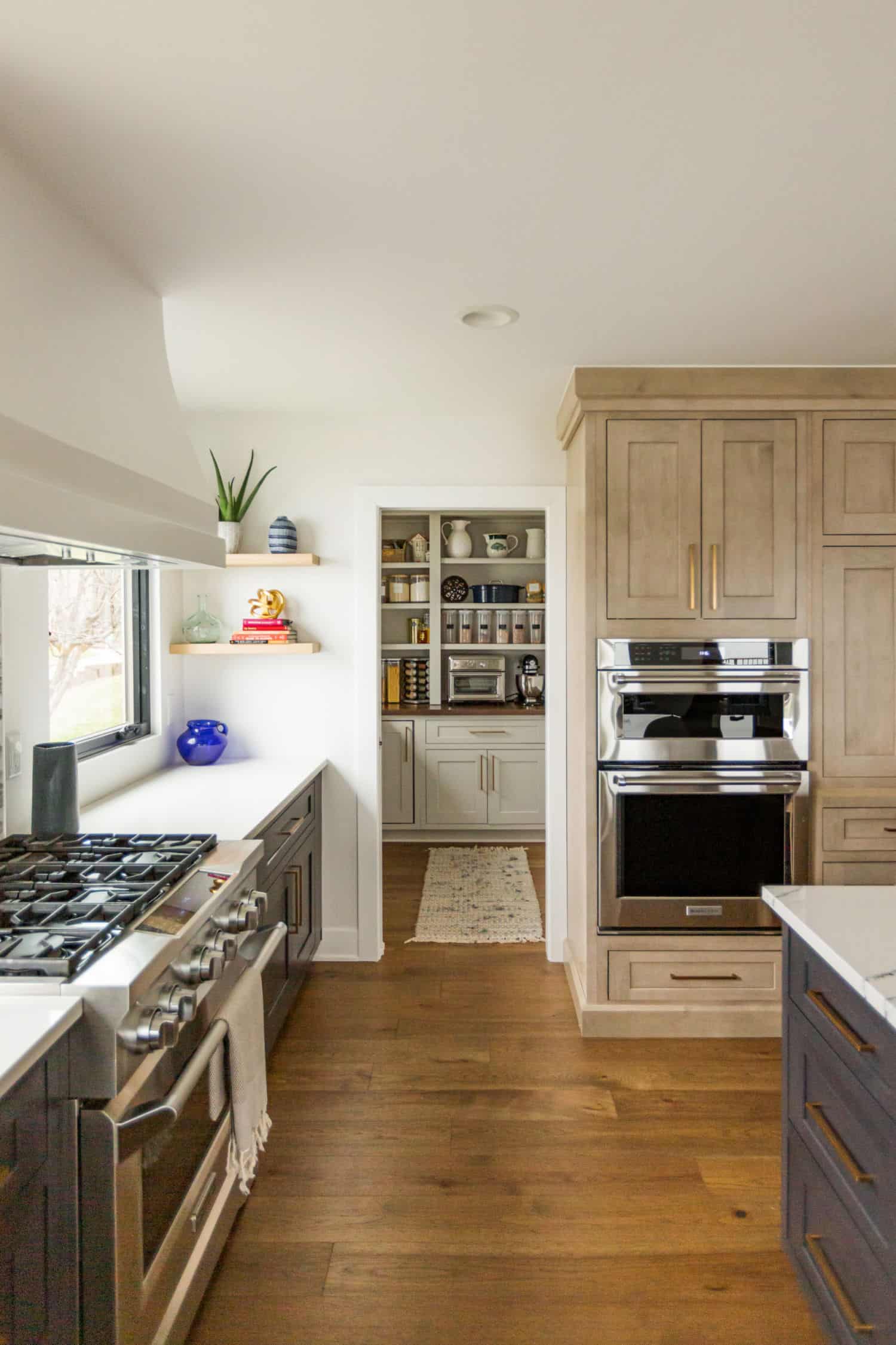 Nicholas Design Build | A remodeled kitchen with wood floors and a stove.