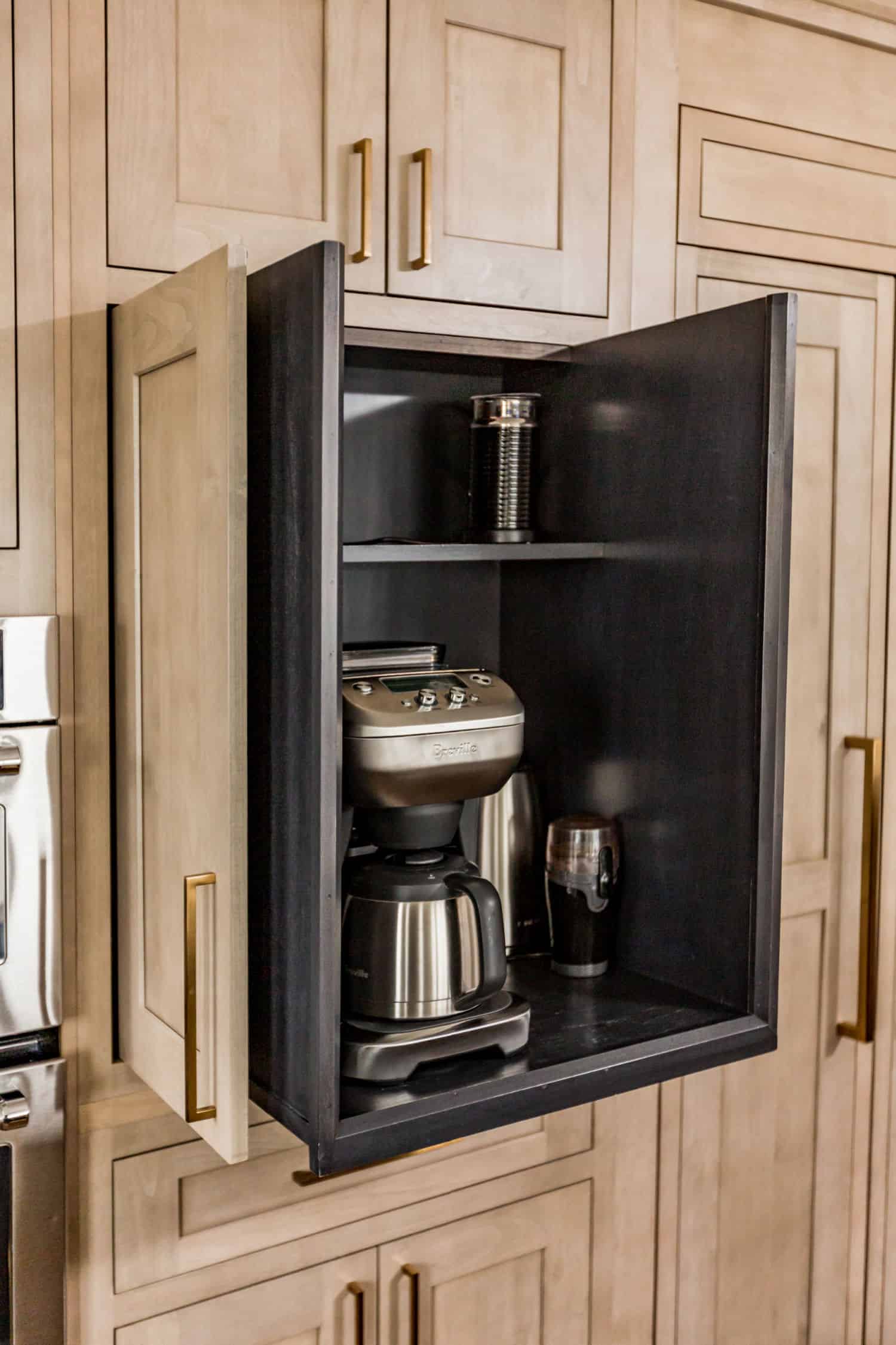 Nicholas Design Build | A coffee maker is in a cabinet in a remodelled kitchen.