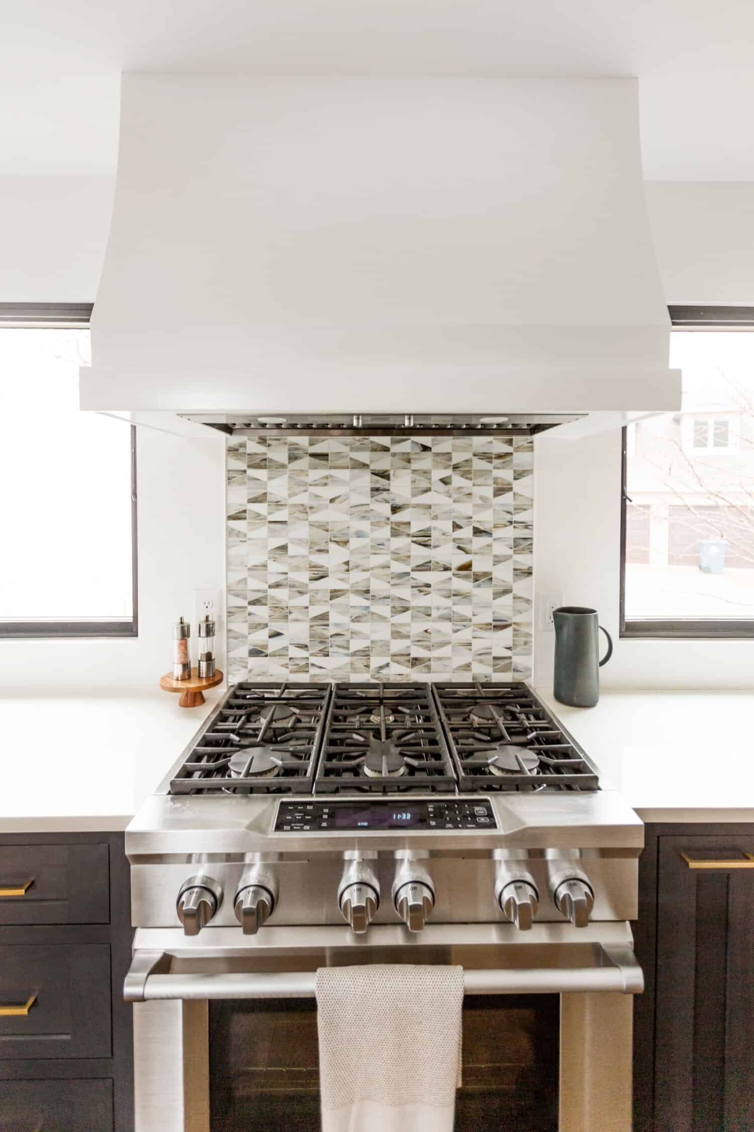 Nicholas Design Build | A remodeled kitchen with a stainless steel stove top.