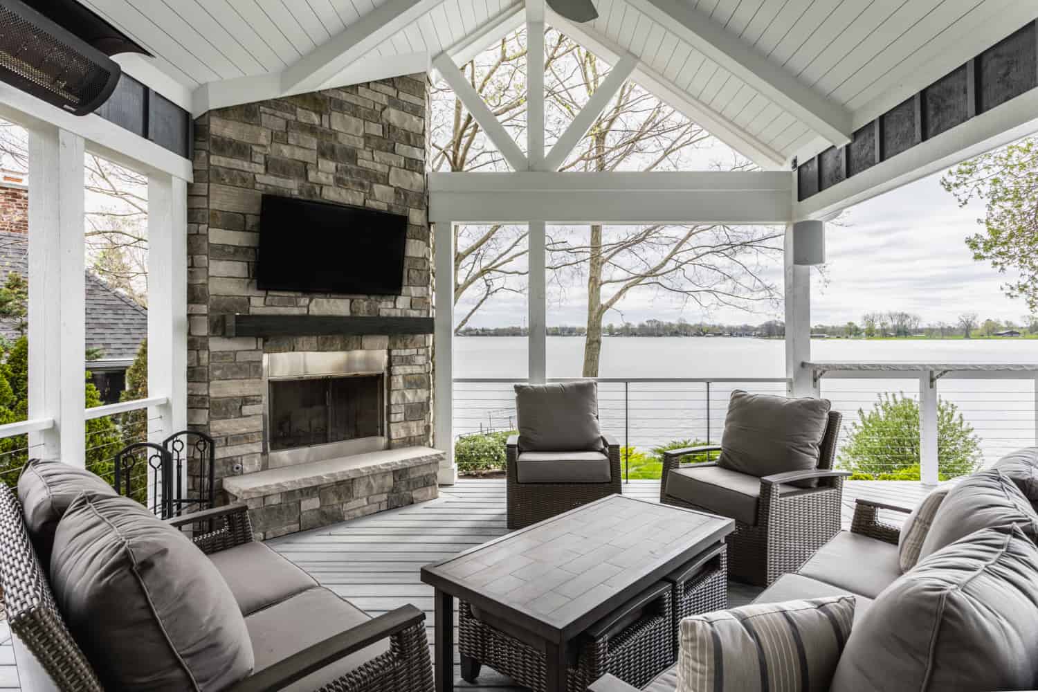 Nicholas Design Build | Description (modified): A remodeled screened in porch with furniture and a fireplace.