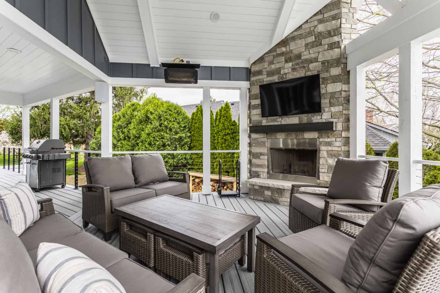 Nicholas Design Build | A remodeled covered patio with furniture and a fireplace.