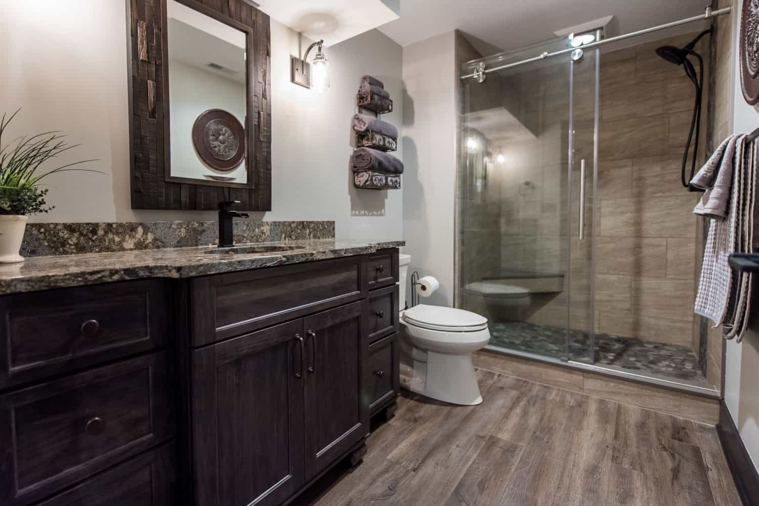 Nicholas Design Build | A remodeled bathroom with wood floors and a walk-in shower.