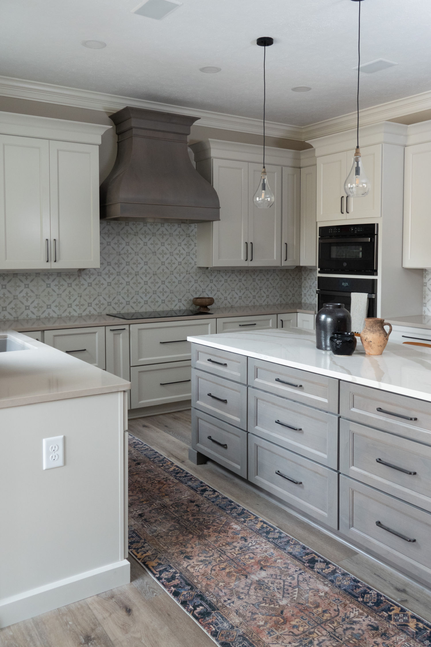 Nicholas Design Build | A remodelled kitchen with white cabinets and gray counter tops.