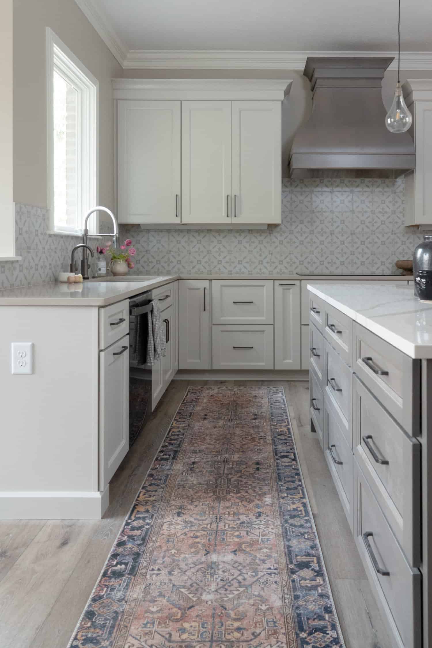 Nicholas Design Build | A kitchen remodel with gray cabinets and a rug on the floor.