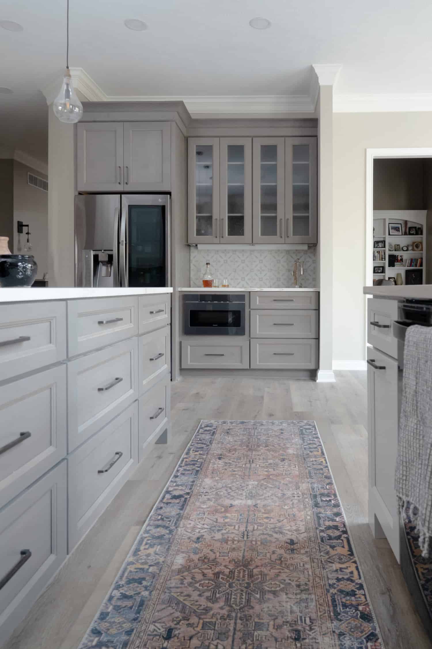 Nicholas Design Build | A kitchen remodel with gray cabinets and a rug on the floor.