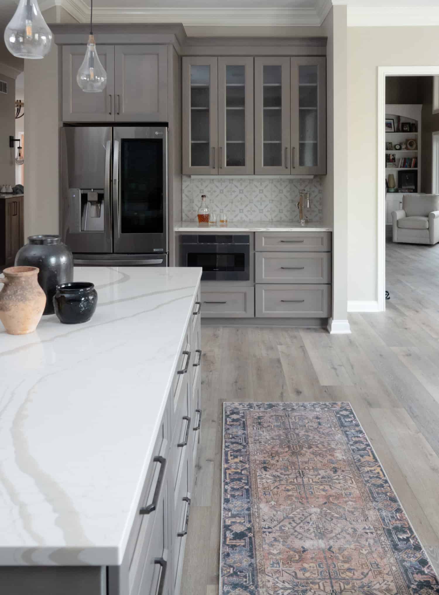 Nicholas Design Build | A remodel of a kitchen with gray cabinets and a rug on the floor.