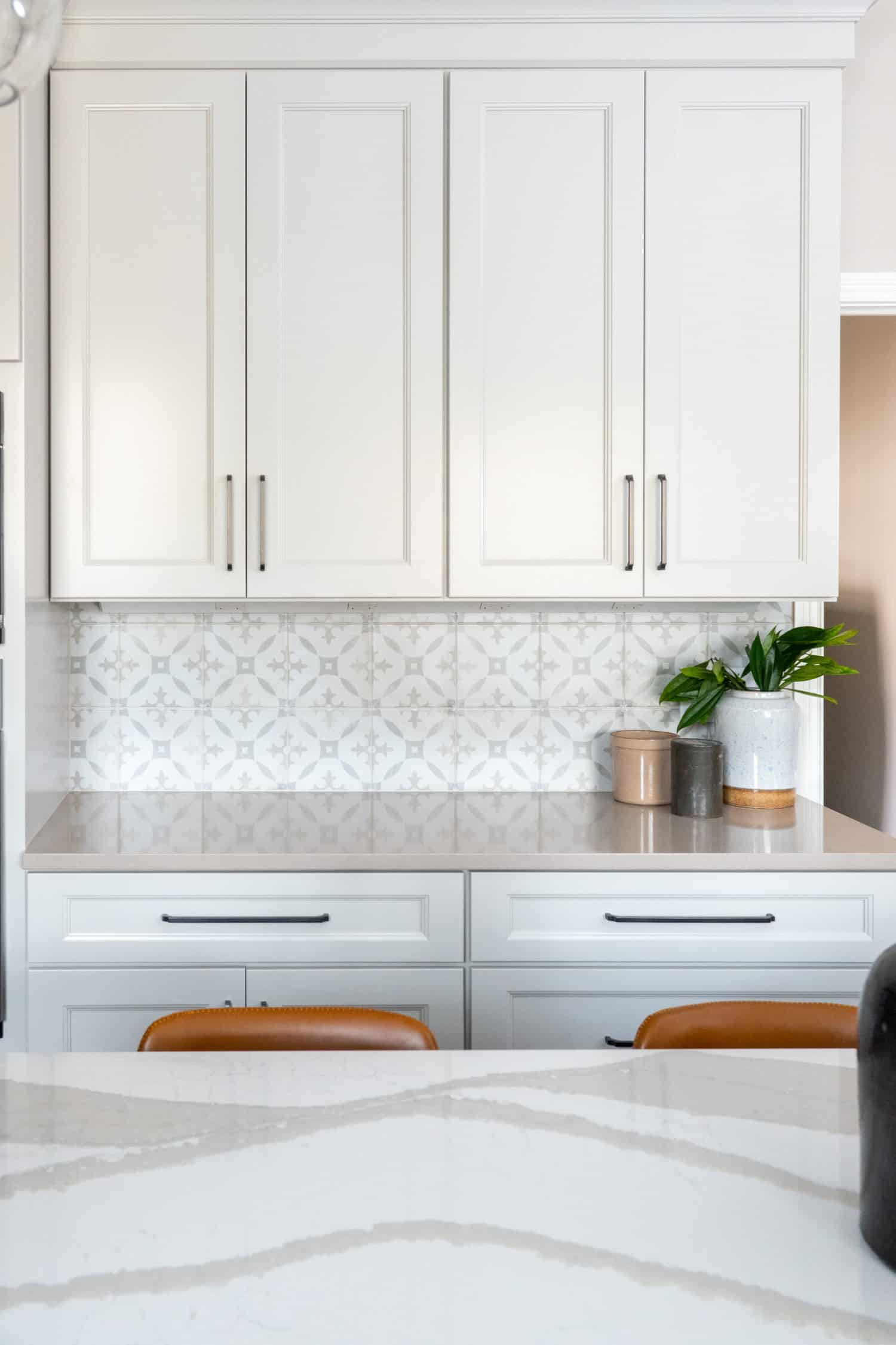 Nicholas Design Build | Remodel: A kitchen with remodeled white cabinets and marble counter tops.