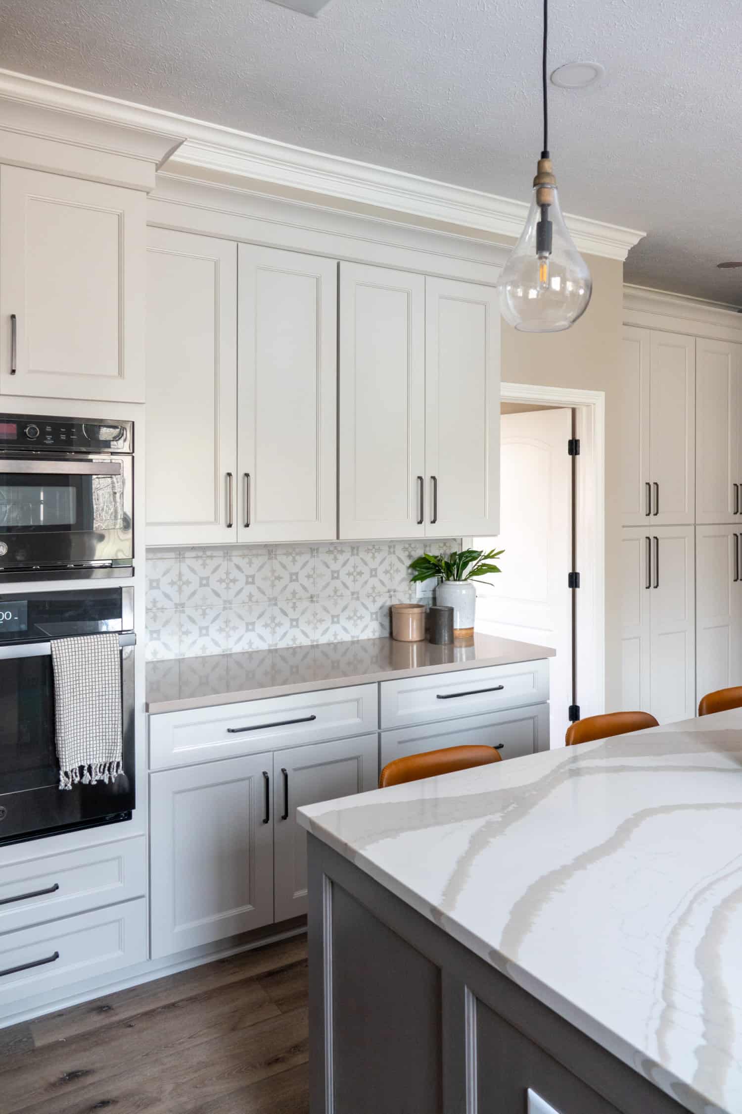 Nicholas Design Build | A remodel of a kitchen with white cabinets and marble counter tops.