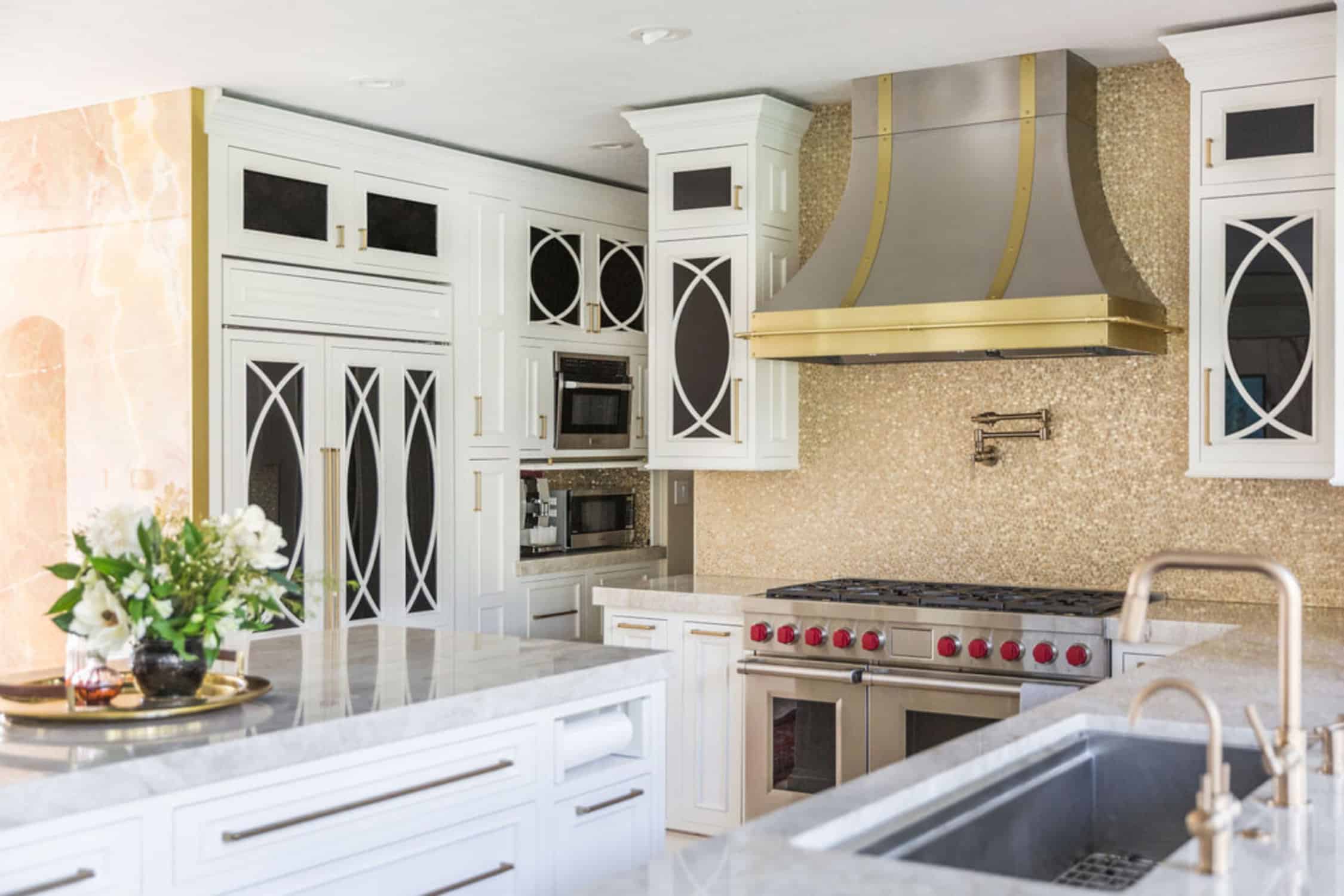 Nicholas Design Build | A remodeled kitchen with a white and gold hood.