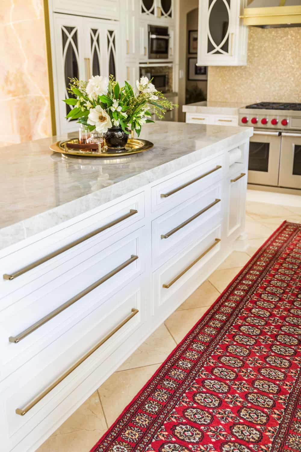 Nicholas Design Build | A remodeled white kitchen with a red rug on the floor.
