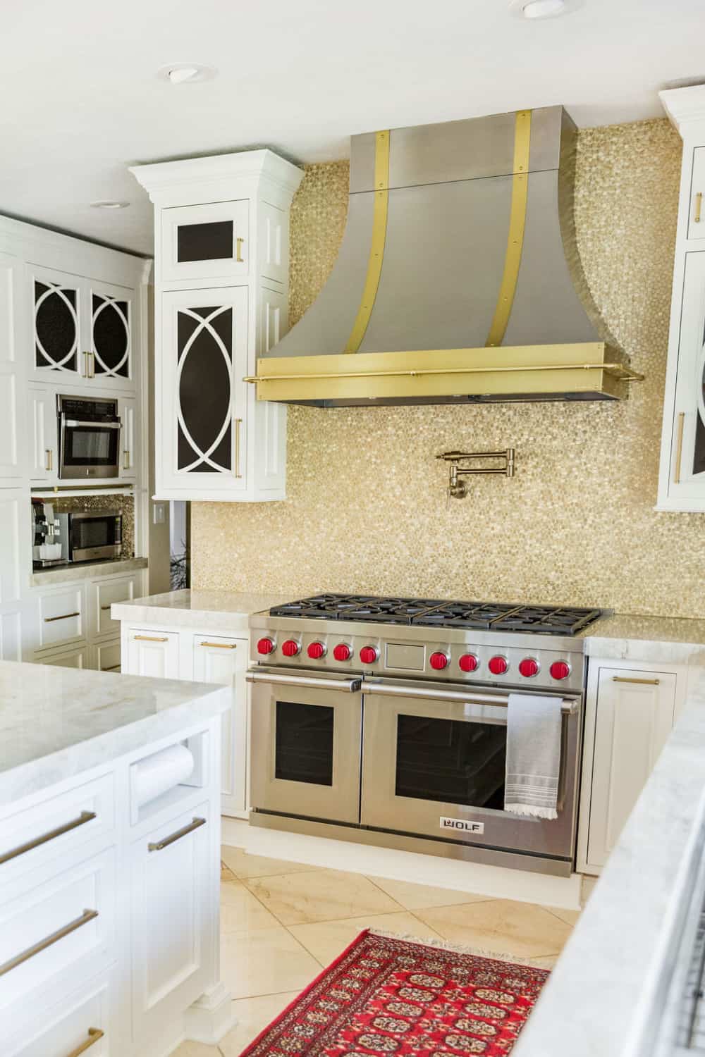 Nicholas Design Build | Remodeling a white kitchen with a stunning gold hood.
