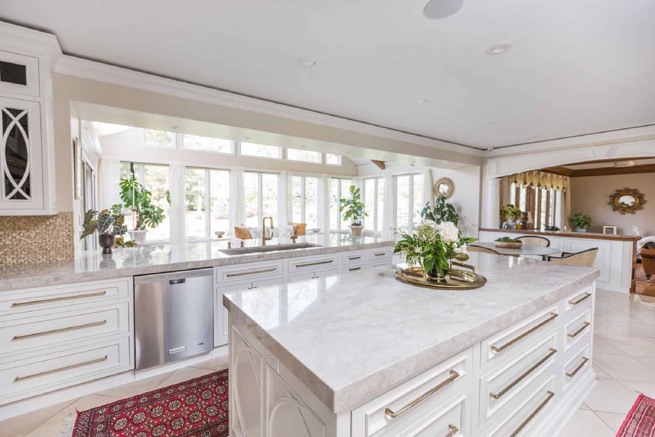 Nicholas Design Build | A large kitchen with white cabinets and a marble counter top, perfect for a remodel.