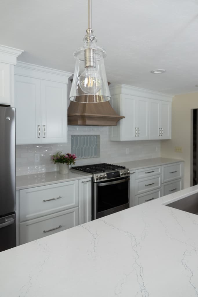 Nicholas Design Build | A remodelled kitchen with stainless steel appliances and marble counter tops.