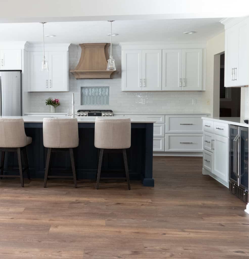 Nicholas Design Build | A remodelled kitchen with white cabinets and hardwood floors.