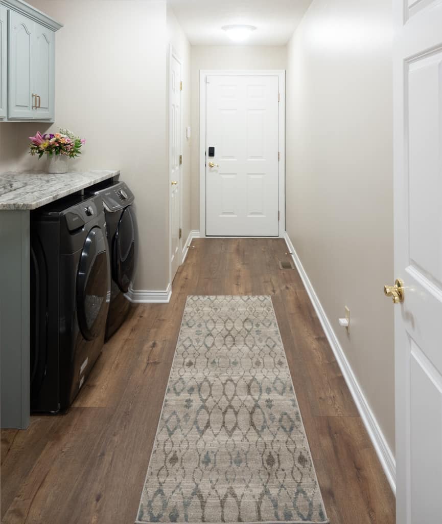 Nicholas Design Build | A remodel of a laundry room with a rug and a washer and dryer.