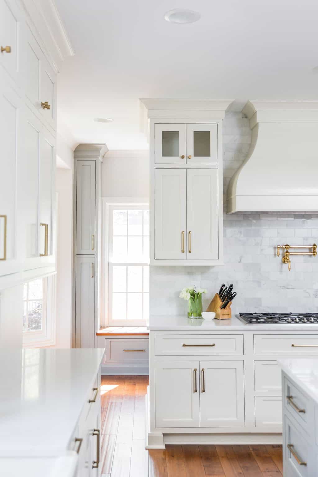 Nicholas Design Build | A remodeled kitchen with white cabinets and gold accents.