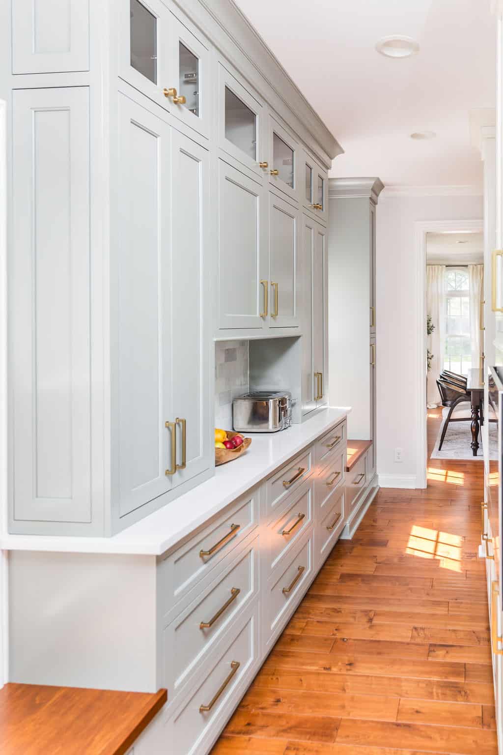 Nicholas Design Build | A kitchen remodel with white cabinets and hardwood floors.