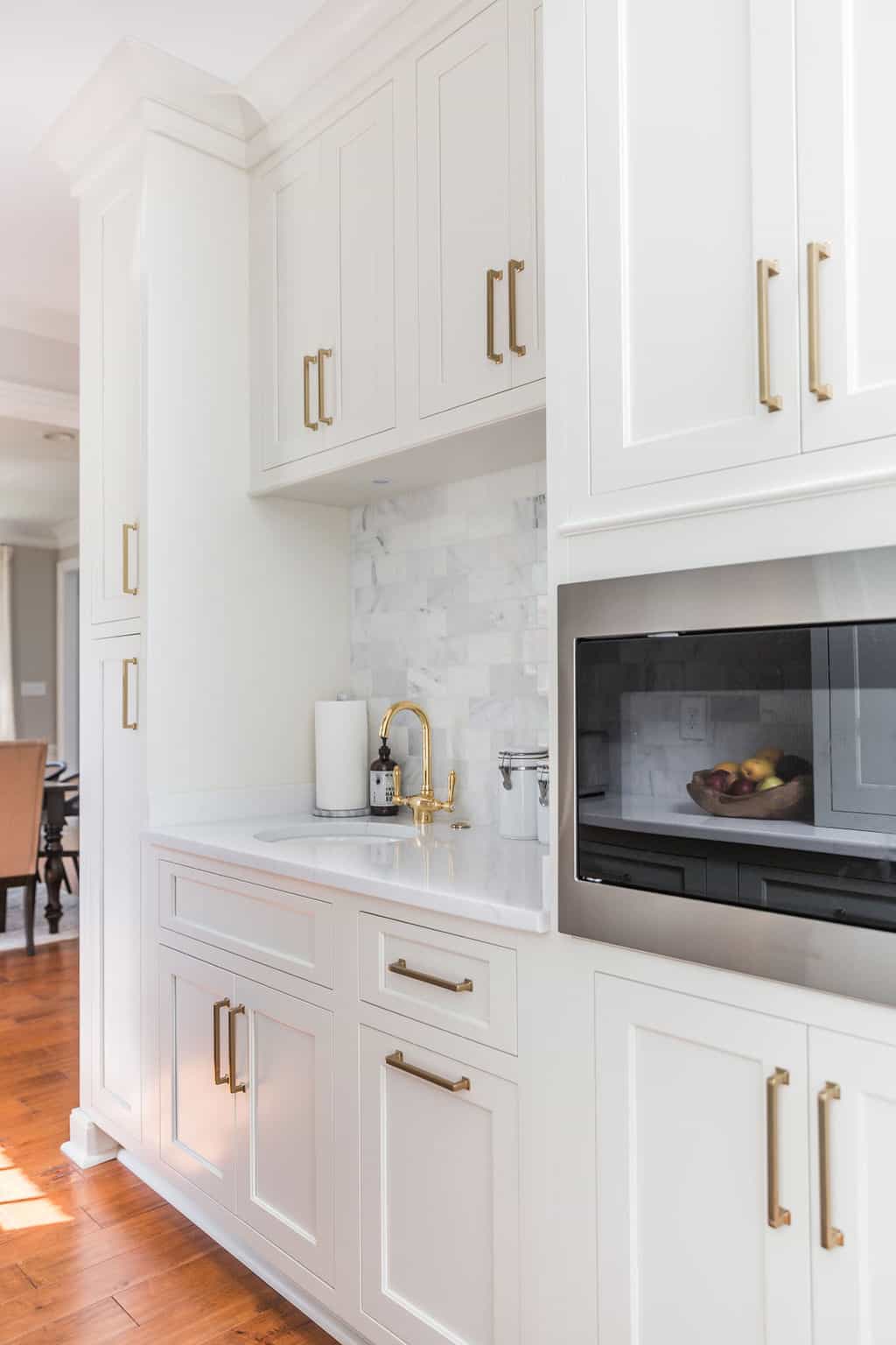 Nicholas Design Build | A remodeled kitchen with white cabinets and a microwave.