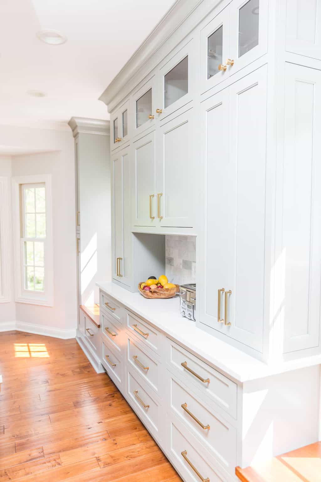 Nicholas Design Build | Remodel a kitchen with white cabinets and hardwood floors.