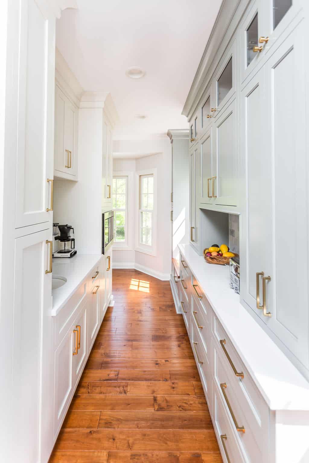 Nicholas Design Build | A remodelled white kitchen with wood floors and white cabinets.
