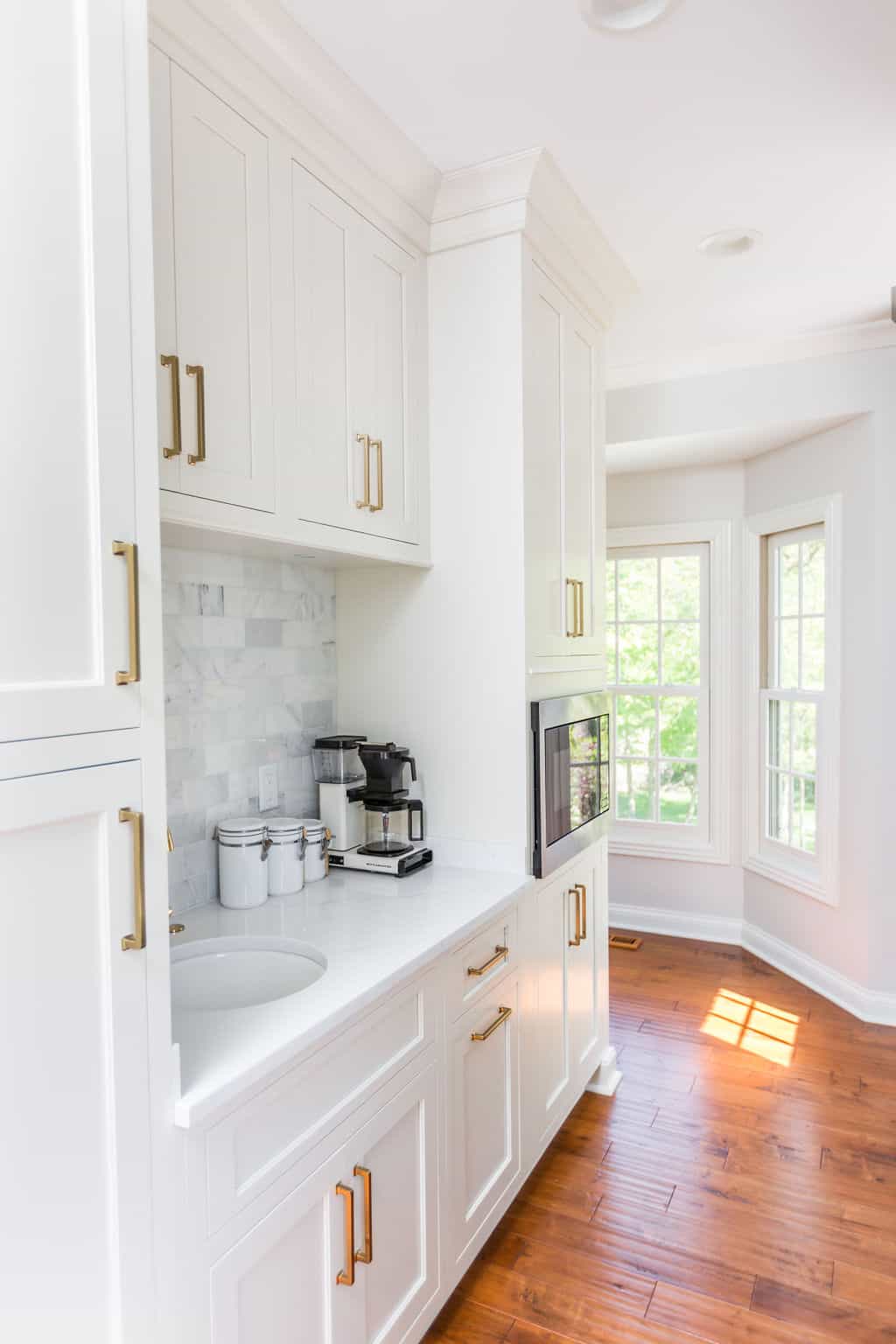 Nicholas Design Build | Remodeling a kitchen with white cabinets and hardwood floors.
