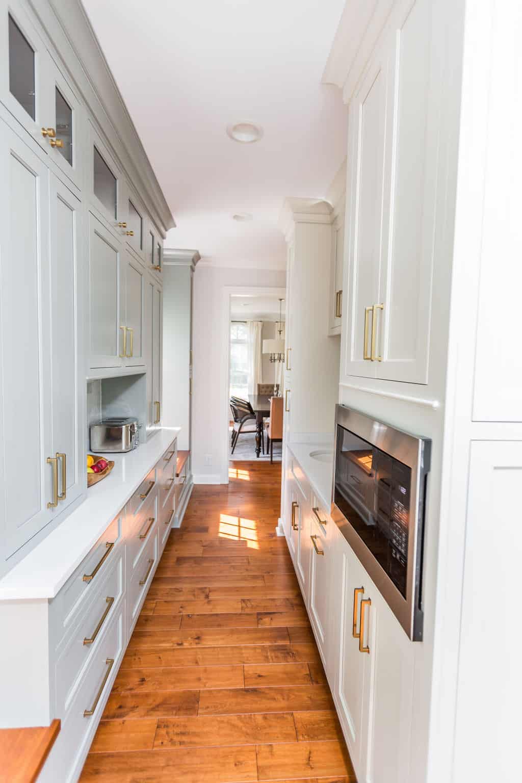 Nicholas Design Build | A kitchen remodel with white cabinets and wood floors.