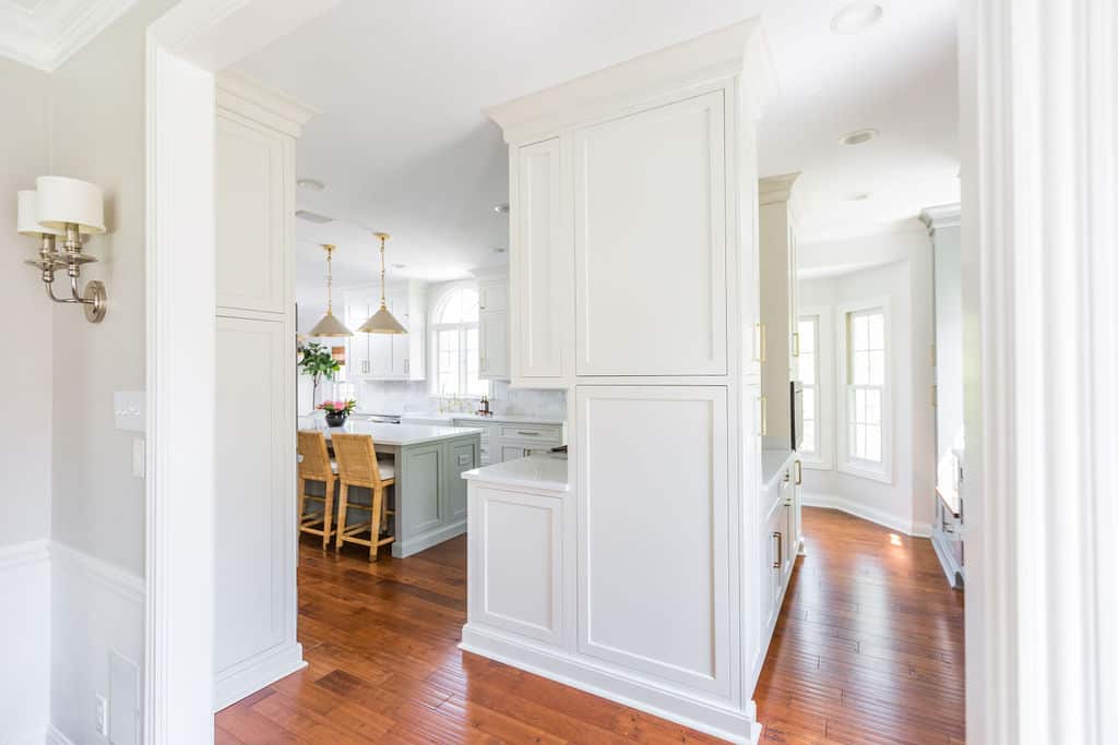Nicholas Design Build | A kitchen remodel with white cabinets and hardwood floors.