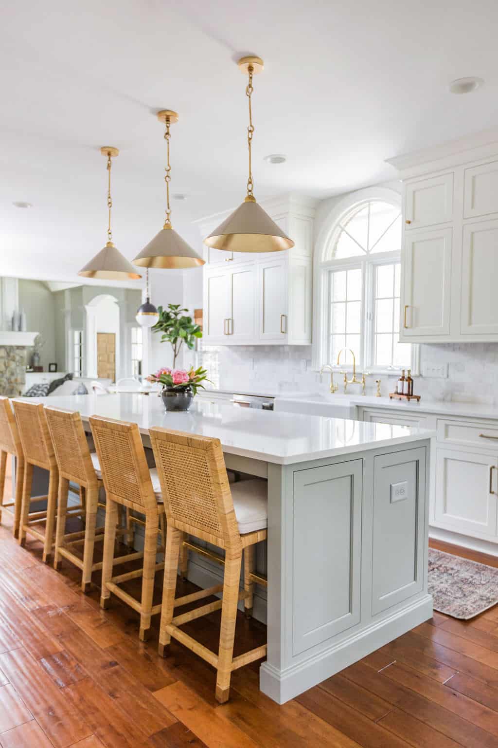 Nicholas Design Build | A white kitchen with wooden floors and stools underwent a remodel.